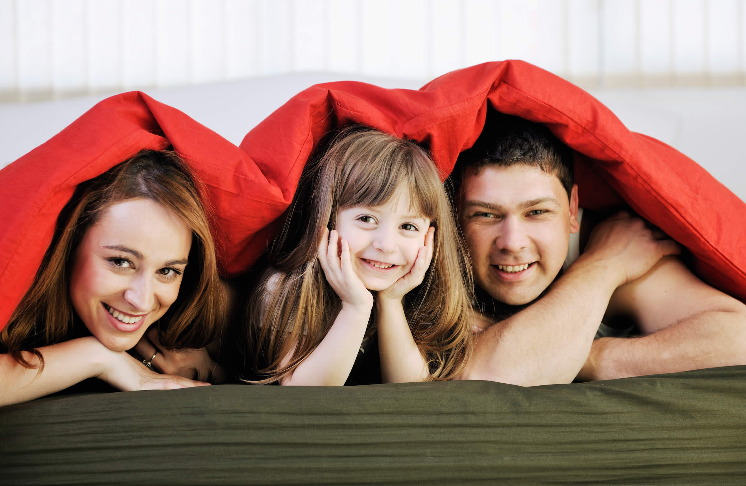 happy family relaxing under the covers