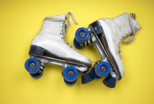 white skates with blue wheels on yellow background