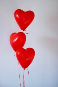 Three red heart-shaped balloons on strings