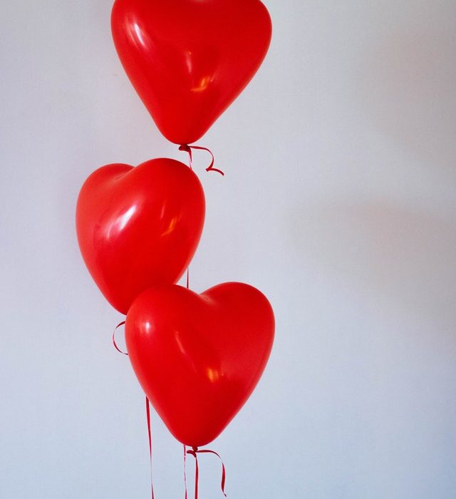 Three red heart-shaped balloons on strings