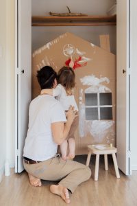 Father and small daughter working on a craft inside