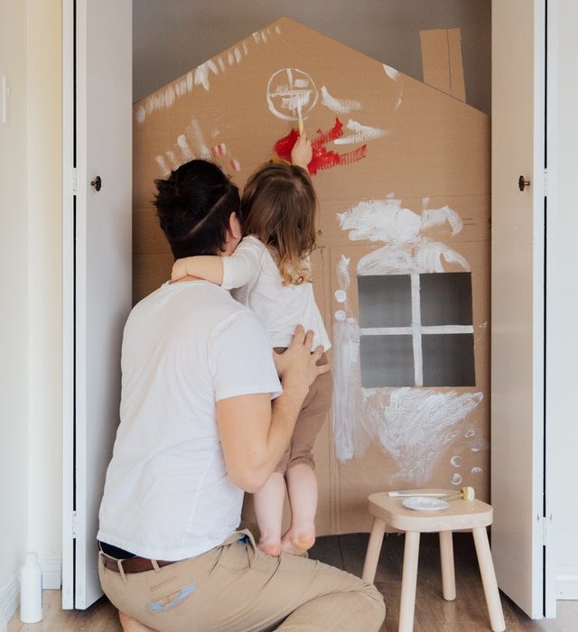 Father and small daughter working on a craft inside